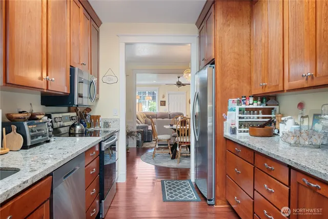 a kitchen with granite countertop a sink dishwasher stove and cabinets