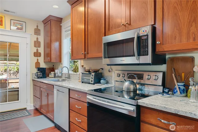 a kitchen with stainless steel appliances granite countertop a sink stove and microwave