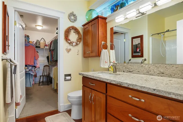 a bathroom with a granite countertop sink a toilet and a mirror