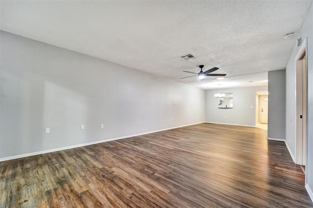 8330 High Point Circle, Unit 6 Port Richey, FL 34668 - Photo 12 of 28 a view of empty room with wooden floor and fan