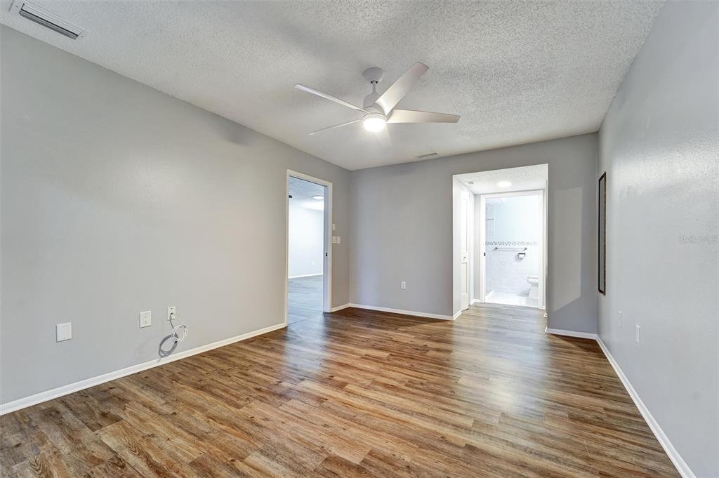 8330 High Point Circle, Unit 6 Port Richey, FL 34668 - Photo 20 of 28 a view of an empty room with wooden floor and a ceiling fan