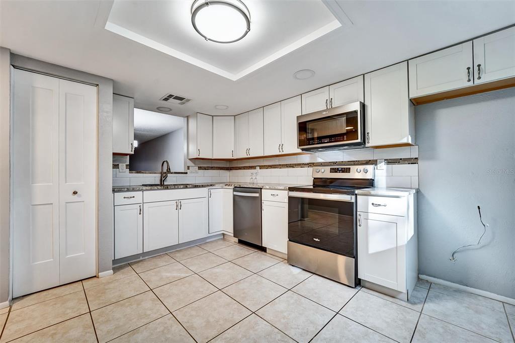 8330 High Point Circle, Unit 6 Port Richey, FL 34668 - Photo 7 of 28 a kitchen with cabinets stainless steel appliances and a counter space