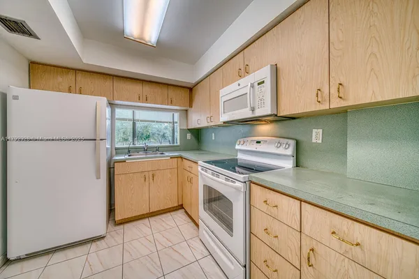 a kitchen with cabinets appliances and a counter space