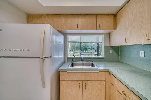 a kitchen with a sink a refrigerator and window