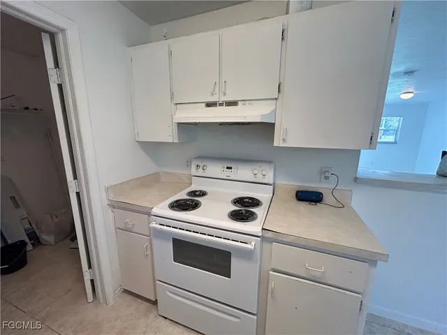 a kitchen with cabinets appliances a sink and a window