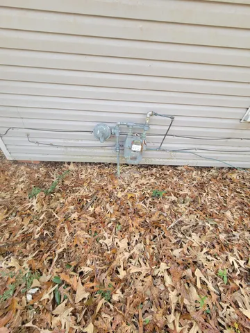 a backyard of a house with large trees and wooden fence