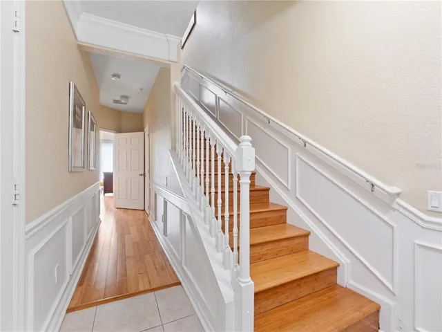 a view of staircase with lots of frames on wall and wooden floor