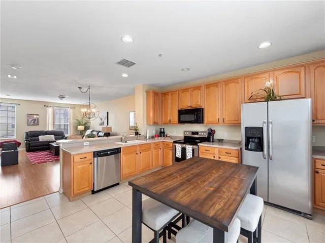 a kitchen with stainless steel appliances granite countertop a stove refrigerator and a sink