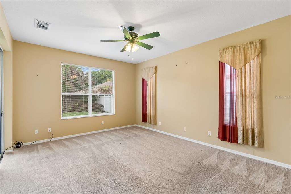 10118 Shortwood Lane Orlando, FL 32836 - Photo 18 of 53 an empty room with windows and chandelier fan