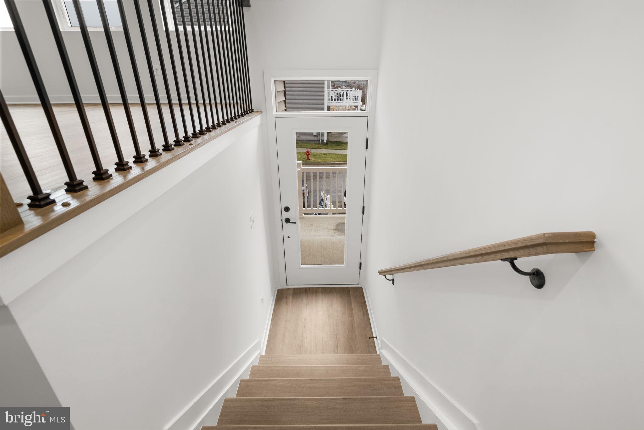 1631 Blacksmith Way, Unit 214B Frederick, MD 21702 - Photo 4 of 41 a view of a hallway with wooden floor and staircase