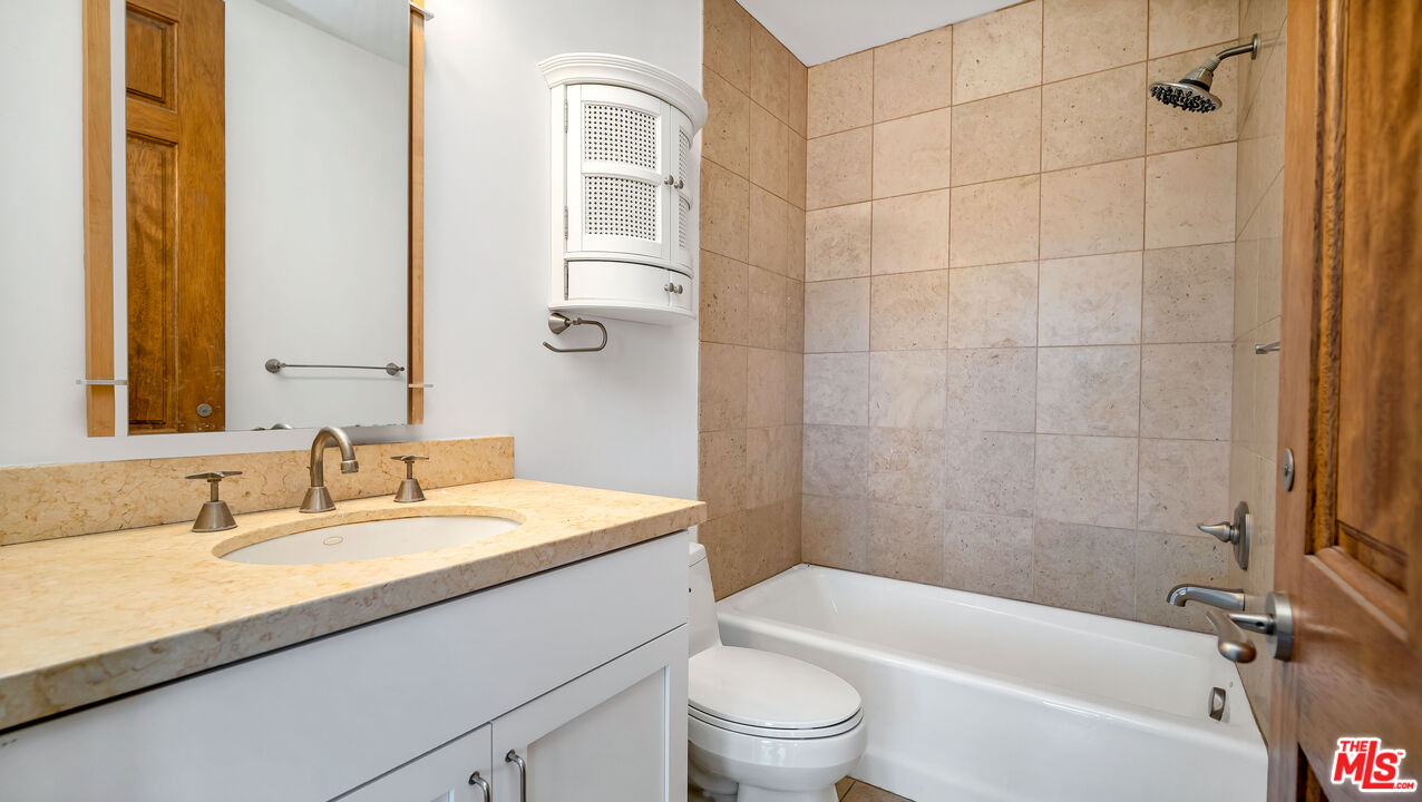 1939 Stradella Road Los Angeles, CA 90077 - Photo 50 of 73 a bathroom with a granite countertop bathtub shower sink vanity mirror and toilet