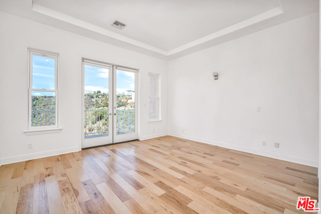 1939 Stradella Road Los Angeles, CA 90077 - Photo 51 of 73 a view of an empty room with wooden floor and a window