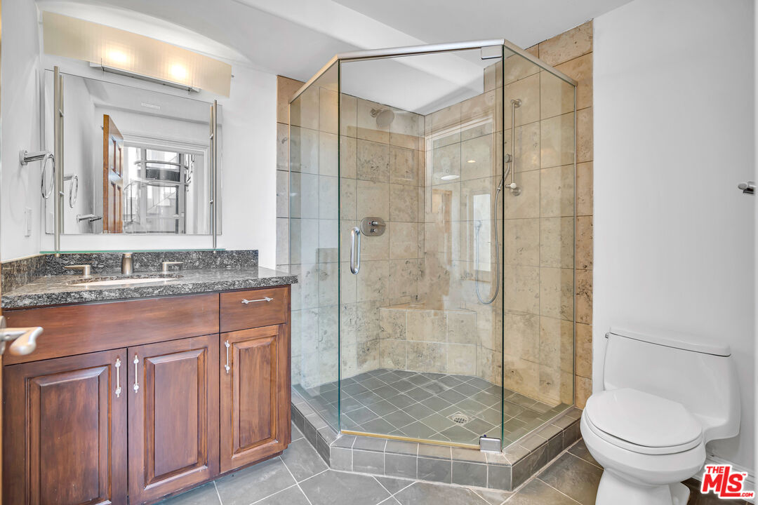 1939 Stradella Road Los Angeles, CA 90077 - Photo 54 of 73 a bathroom with a granite countertop shower a mirror and a sink
