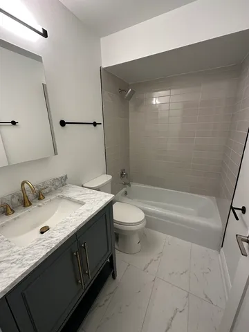 a bathroom with a granite countertop sink toilet and shower