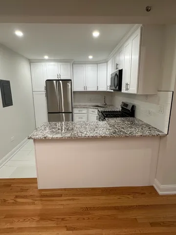 a view of kitchen with stainless steel appliances granite countertop refrigerator sink and stove