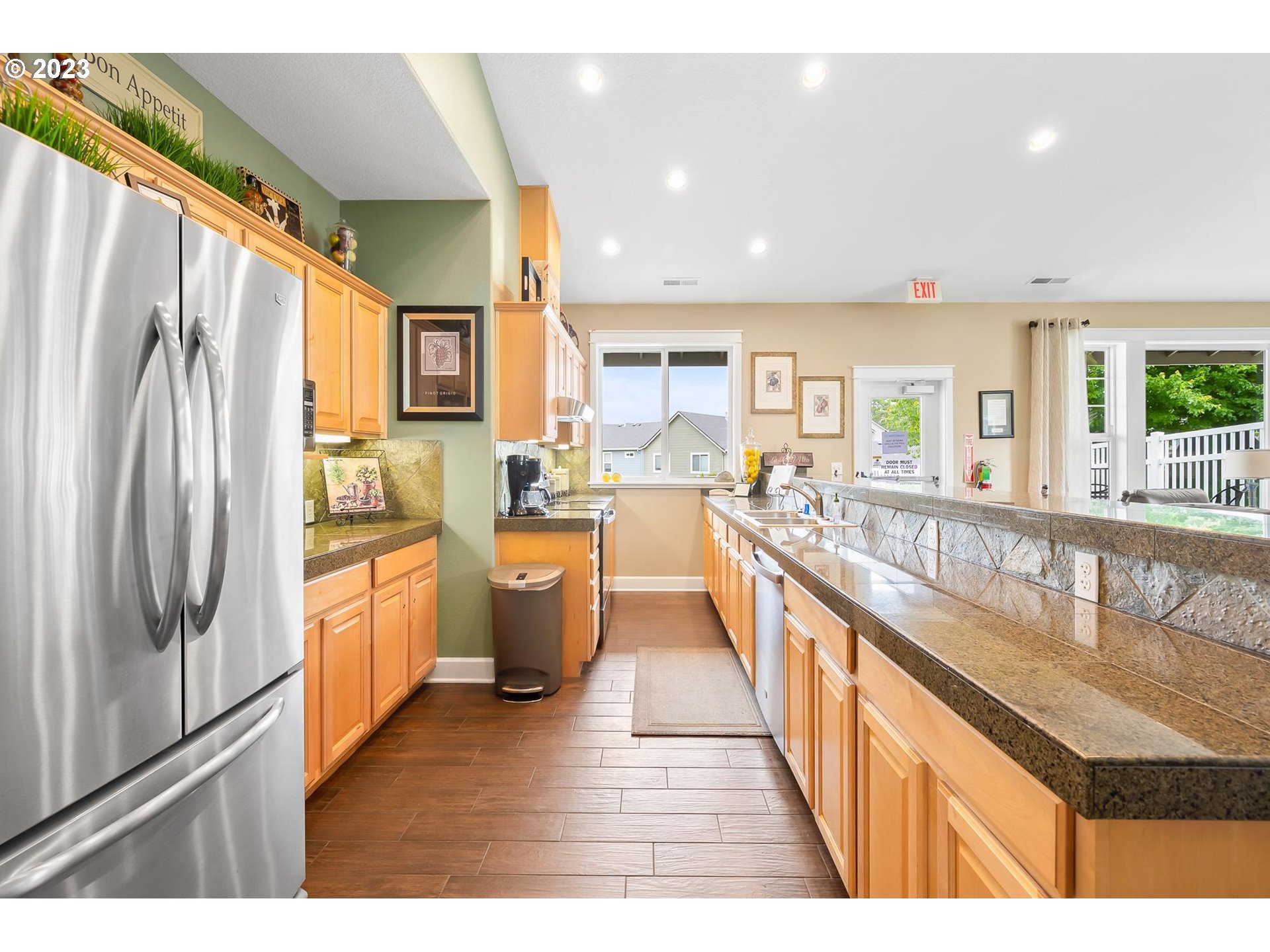 2830 Northeast Blossom Hill Road Fairview, OR 97024 - Photo 27 of 34 a kitchen with stainless steel appliances granite countertop a refrigerator a sink dishwasher a stove and a dining table with wooden floor