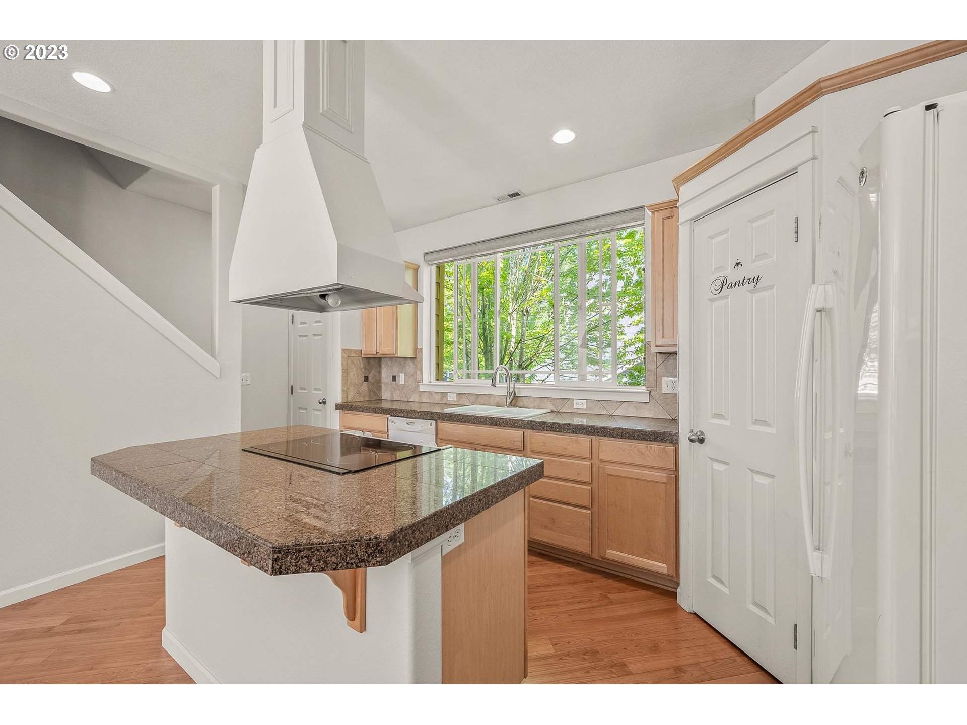 2830 Northeast Blossom Hill Road Fairview, OR 97024 - Photo 9 of 34 a kitchen with kitchen island granite countertop a sink and a refrigerator