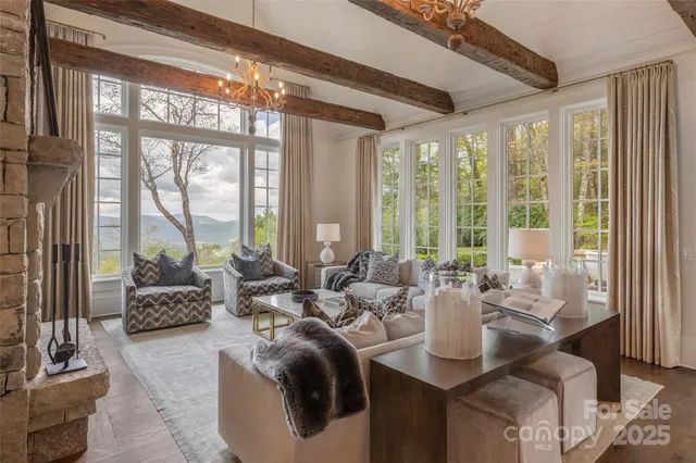 a living room with furniture and floor to ceiling windows