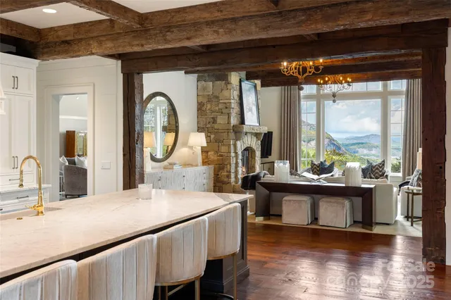 a living room with stainless steel appliances granite countertop furniture a fireplace and a large window