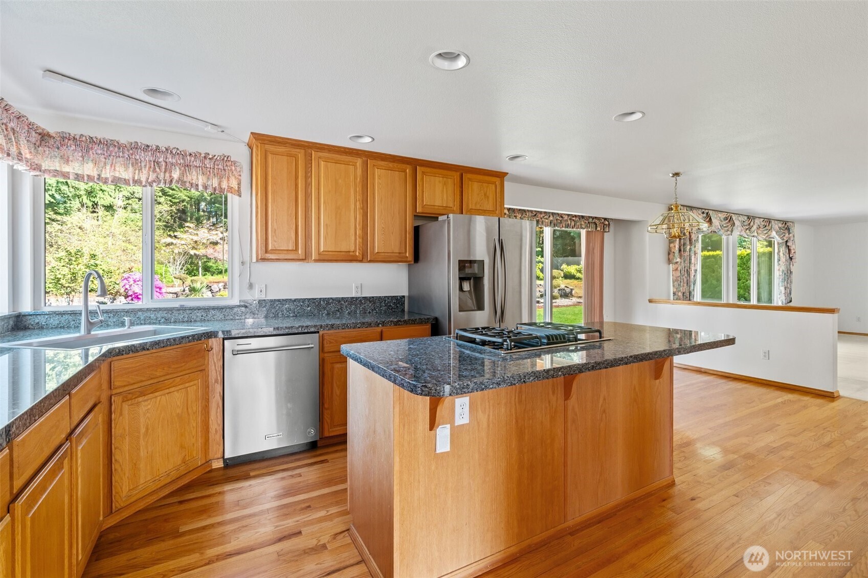 9536 Marlbrook Loop Southeast Olympia, WA 98513 - Photo 22 of 40 a kitchen with kitchen island granite countertop a sink cabinets and wooden floor