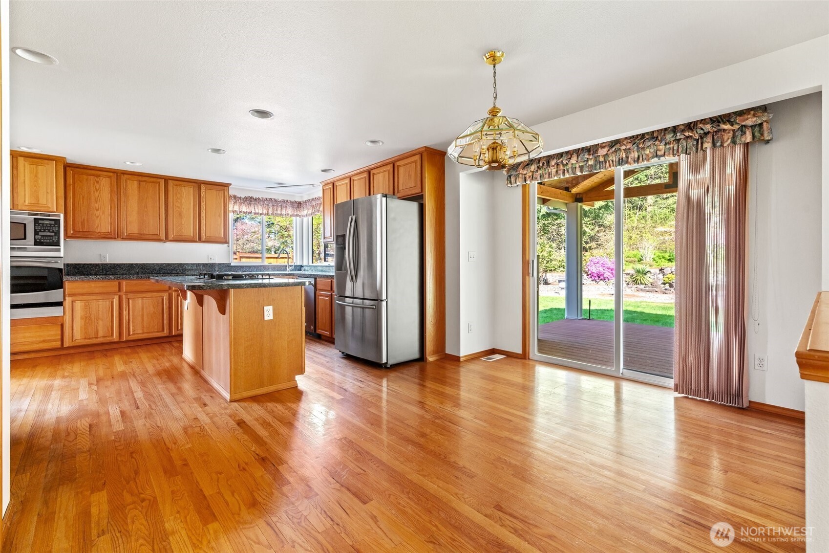 9536 Marlbrook Loop Southeast Olympia, WA 98513 - Photo 24 of 40 a kitchen with stainless steel appliances granite countertop a refrigerator a stove and a wooden floors