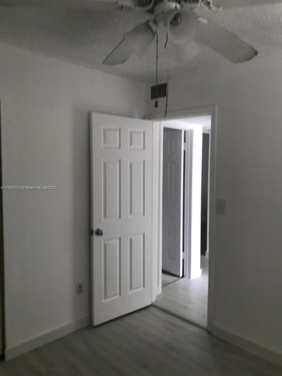 438 Northeast 210th Cir Terrace, Unit 2034B Miami, FL 33179 - Photo 12 of 20 an empty room with a hallway
