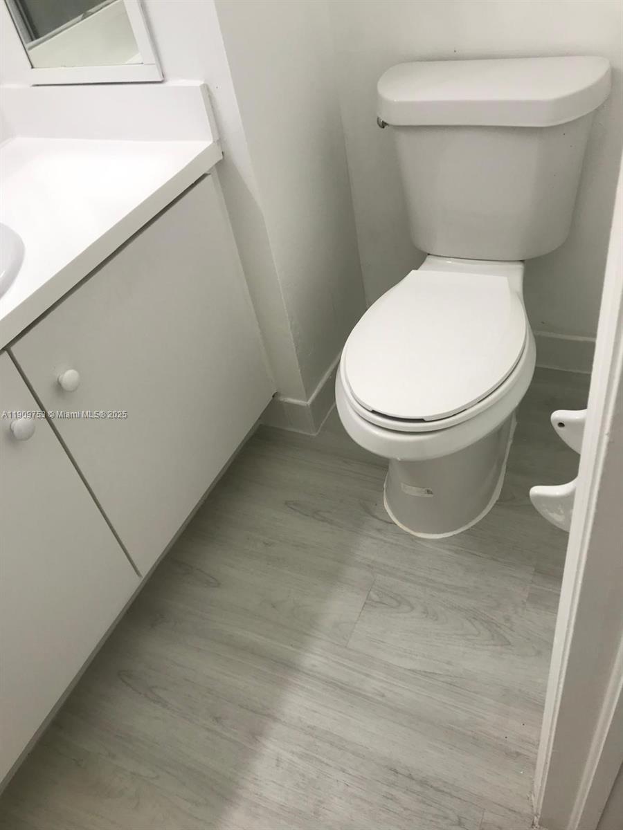 438 Northeast 210th Cir Terrace, Unit 2034B Miami, FL 33179 - Photo 16 of 20 a white toilet sitting next to a white sink and vanity