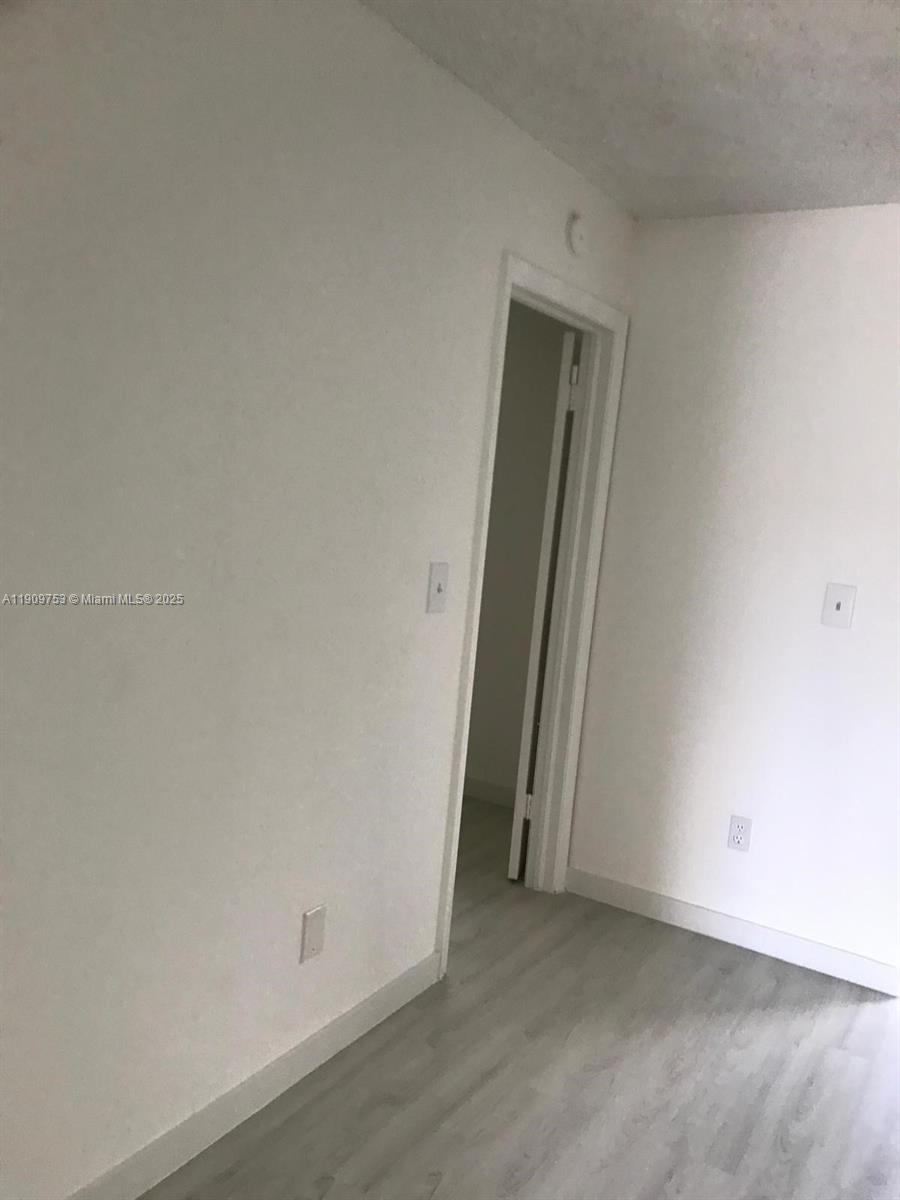 438 Northeast 210th Cir Terrace, Unit 2034B Miami, FL 33179 - Photo 18 of 20 an empty room with a door
