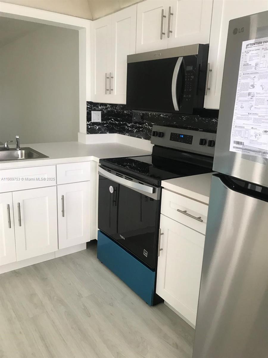 438 Northeast 210th Cir Terrace, Unit 2034B Miami, FL 33179 - Photo 6 of 20 a kitchen with a stove and a sink