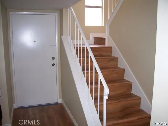 a view of staircase with wooden floor and white walls