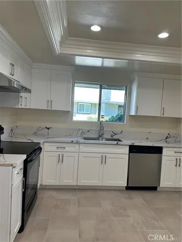 a kitchen with granite countertop white cabinets and white appliances