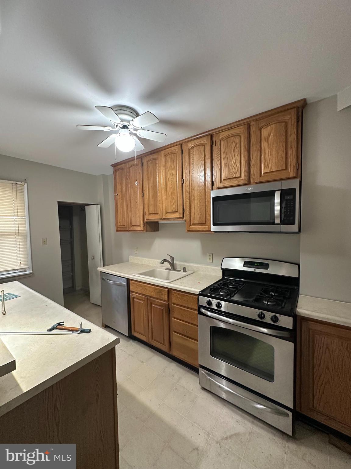 6822 Dunbar Road Baltimore, MD 21222 - Photo 6 of 20 a kitchen with granite countertop a stove cabinets and refrigerator