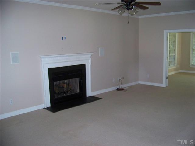 2629 Jasper Lane Raleigh, NC 27613 - Photo 3 of 7 an empty room with a fireplace and chandelier fan