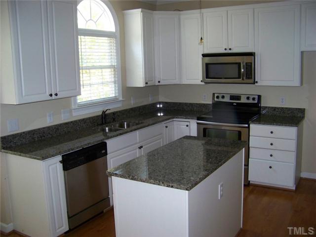 2629 Jasper Lane Raleigh, NC 27613 - Photo 4 of 7 a kitchen with granite countertop white cabinets sink and stainless steel appliances