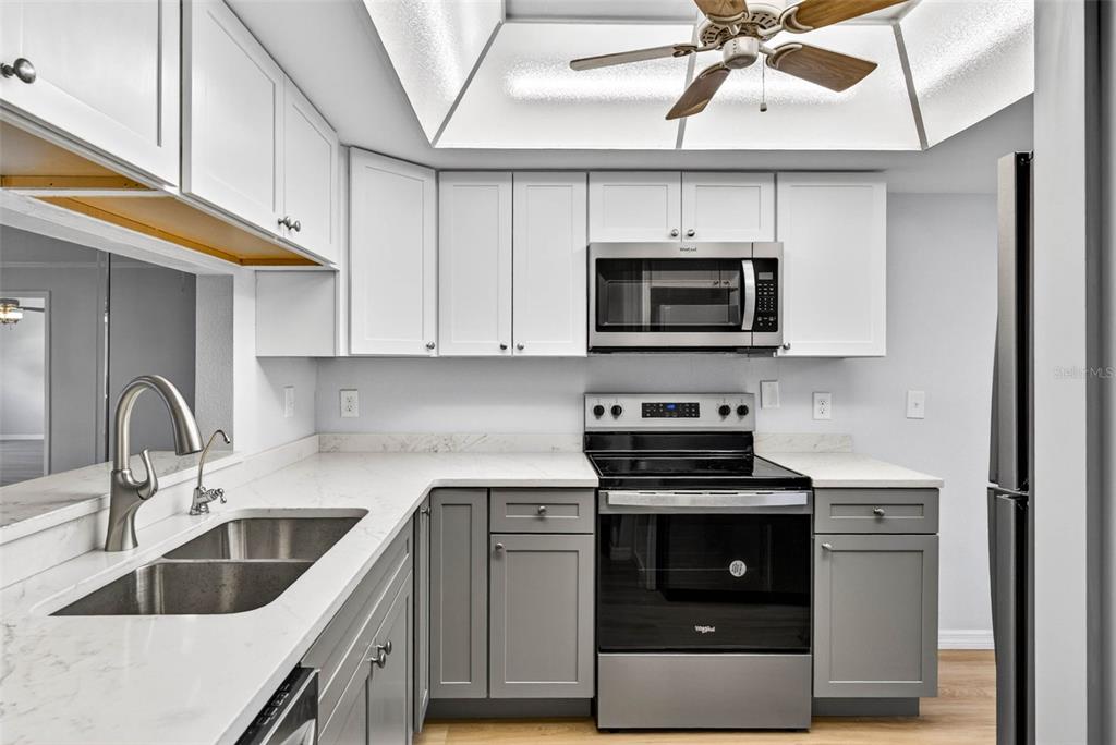 5197 Silent Loop, Unit 124 New Port Richey, FL 34652 - Photo 9 of 55 a kitchen with stainless steel appliances a stove a sink and a microwave