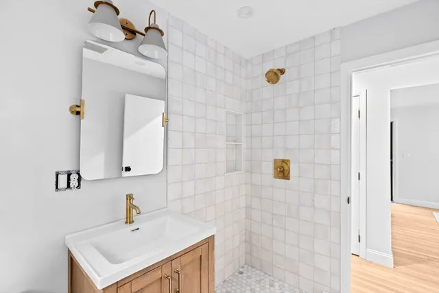 a bathroom with a sink a mirror and shower