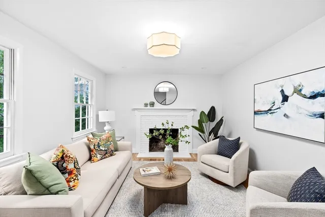 a living room with furniture a fireplace and a large mirror