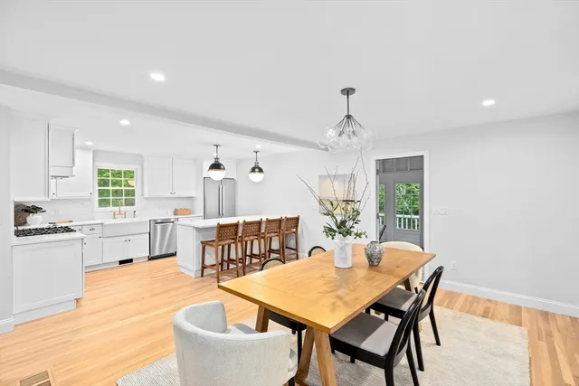 a dining room with furniture a chandelier and wooden floor
