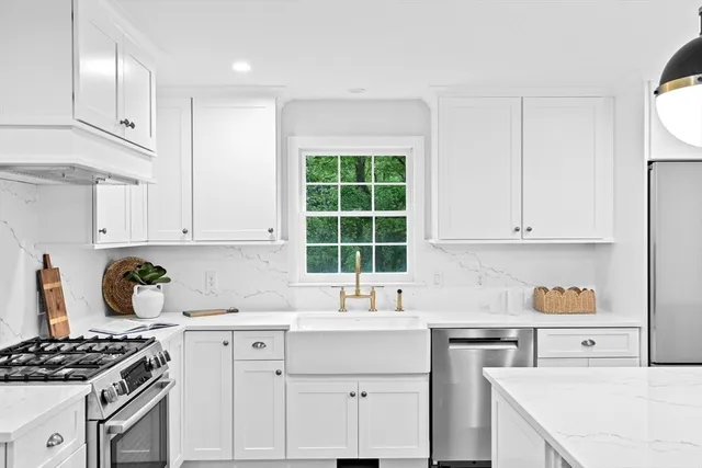 a kitchen with granite countertop a sink stove and cabinets
