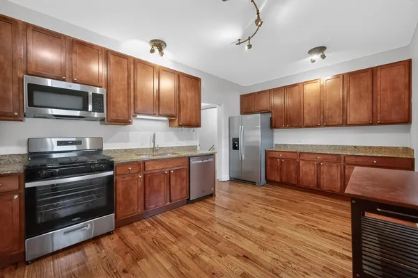 a kitchen with stainless steel appliances wooden cabinets and a stove top oven