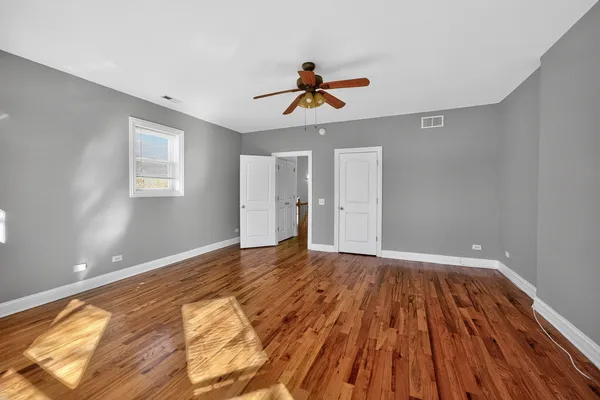 a view of an empty room with window and wooden floor