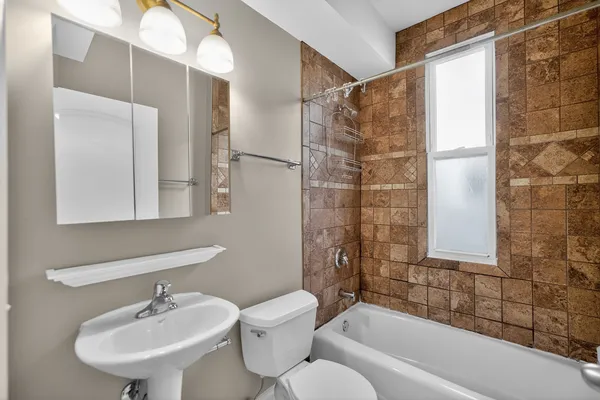 a bathroom with a bathtub shower sink and toilet