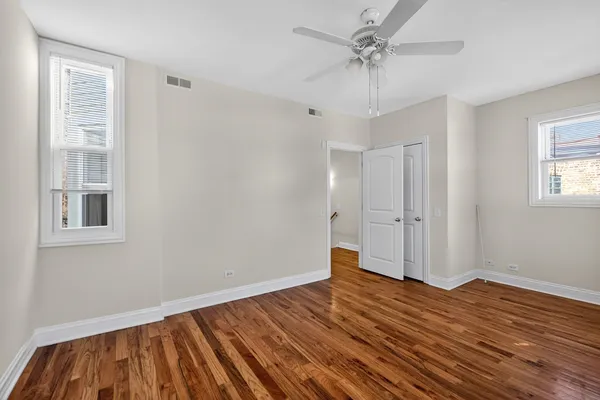 a view of a livingroom with wooden floor and a ceiling fan