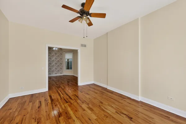 a view of empty room with wooden floor