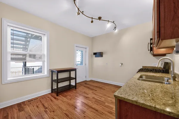 a view of a kitchen with wooden floor and a sink