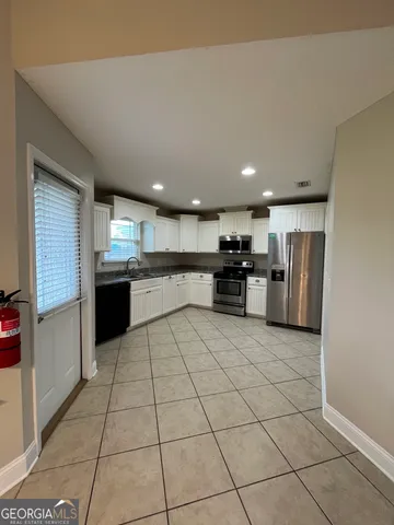 a kitchen with stainless steel appliances granite countertop a refrigerator and a stove top oven