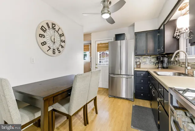 a kitchen with stainless steel appliances granite countertop a refrigerator a sink a stove and a wooden floors