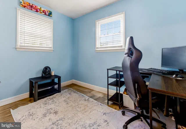a view of a workspace with furniture and a window