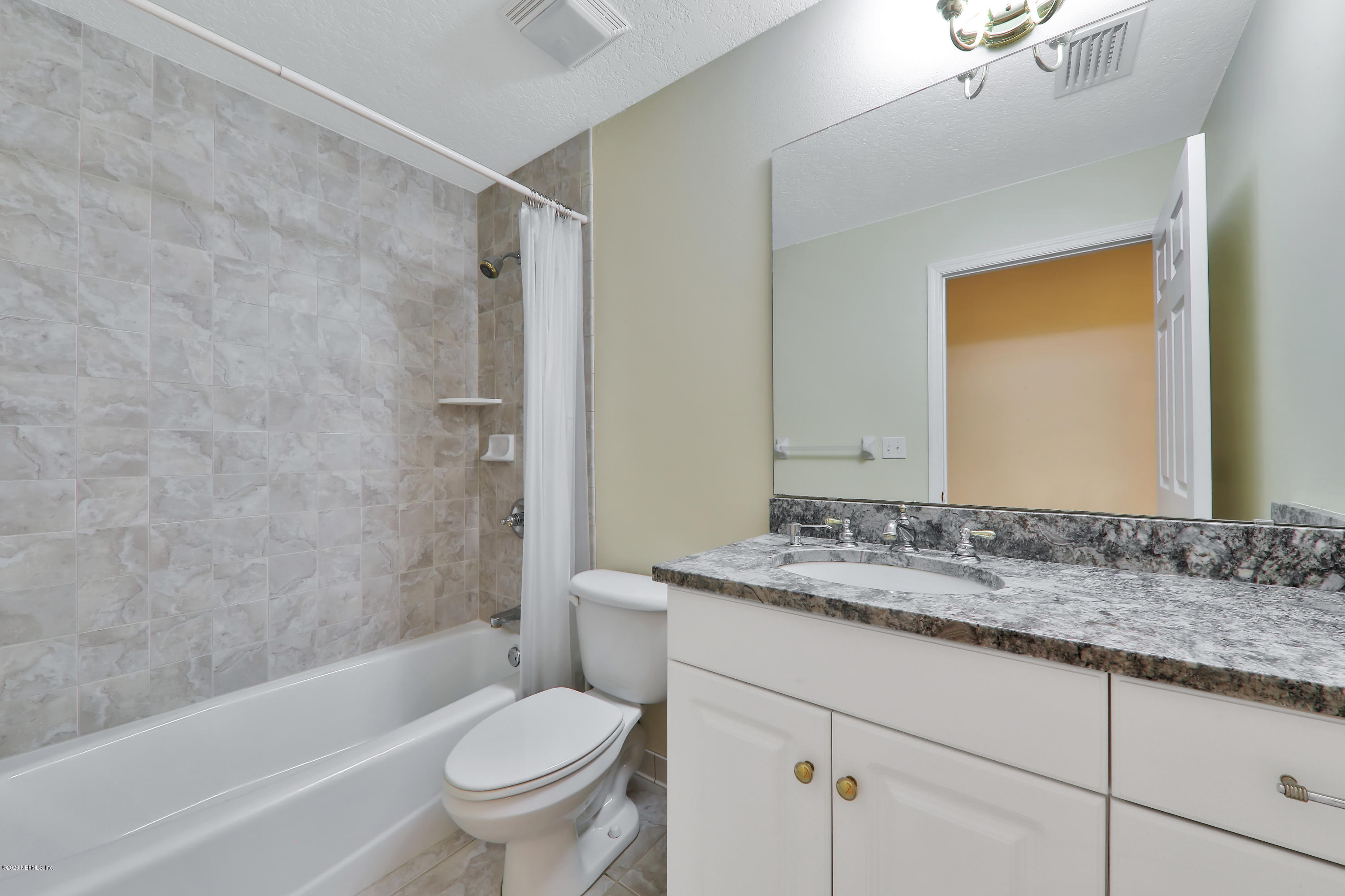 3289 Kings Road South St. Augustine, FL 32086 - Photo 18 of 41 a bathroom with a granite countertop sink a toilet and shower