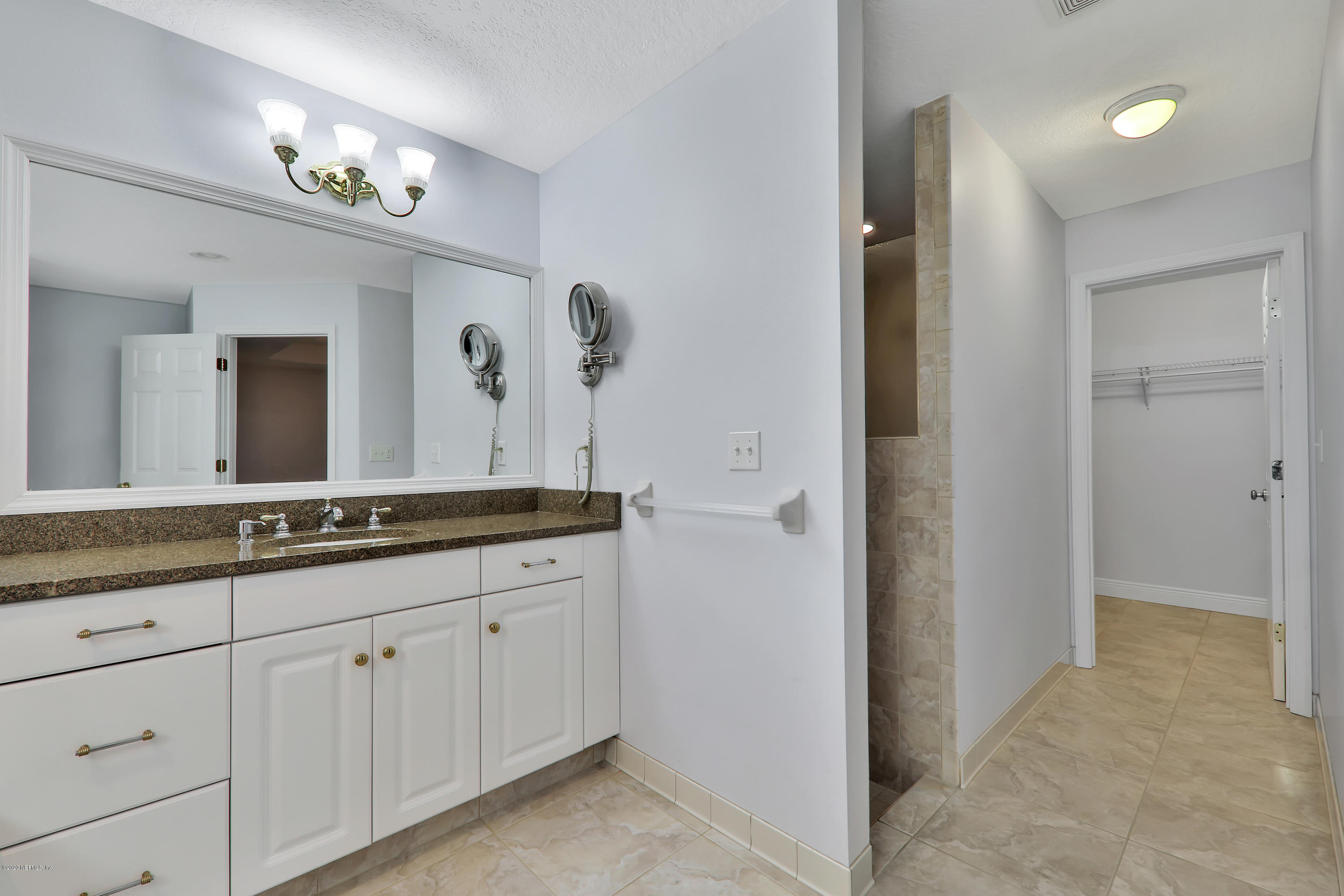 3289 Kings Road South St. Augustine, FL 32086 - Photo 22 of 41 a spacious bathroom with a granite countertop sink a mirror and a